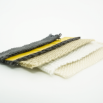 Vier verschiedene hitzebeständige, gewebte Bänder in Grau, Beige und Weiß, nebeneinander auf einem gelben Träger präsentiert, für industrielle Isolations- und Hochtemperaturanwendungen. thumbnail